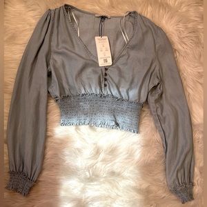 Long sleeve V-neck light blue top with ruching detail